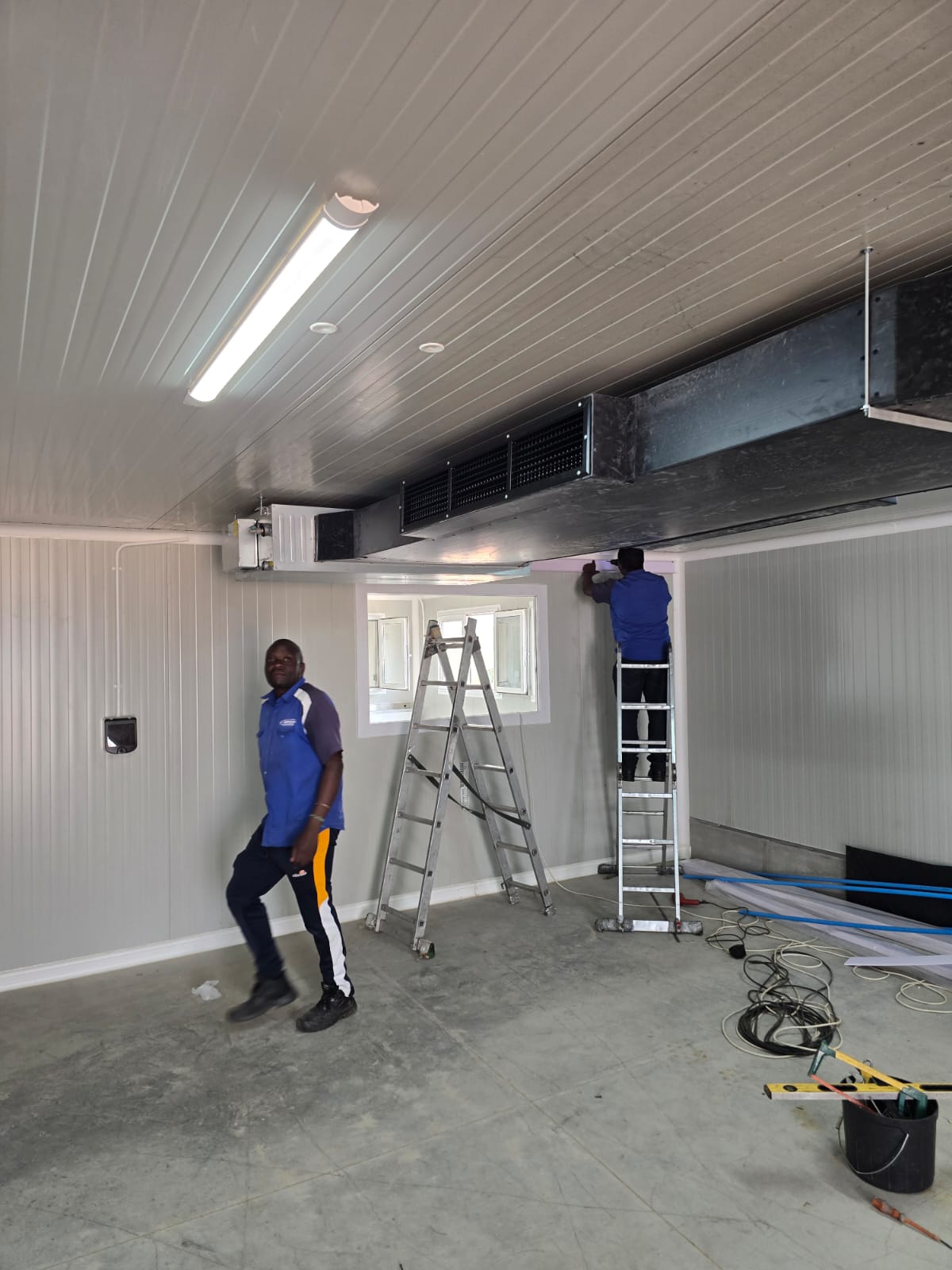 Airtech technicians installing ducted air conditioning on a commercial site